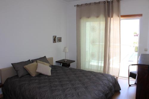 a bedroom with a bed and a large window at Modern 1 bedrom apartment in Albufeira