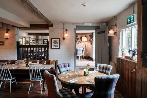 a dining room with wooden tables and chairs at Hinds Head in Aldermaston