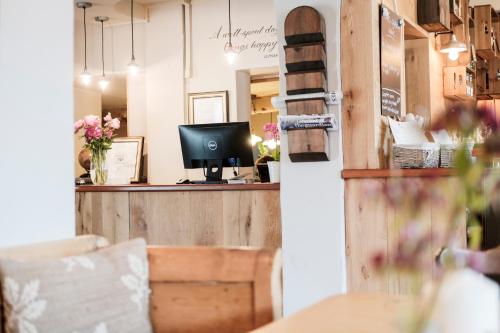 a dining room with a television and a table at Hinds Head in Aldermaston