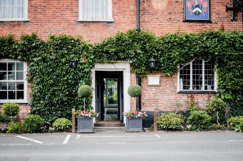 a brick building with a door with plants on it at Hinds Head in Aldermaston