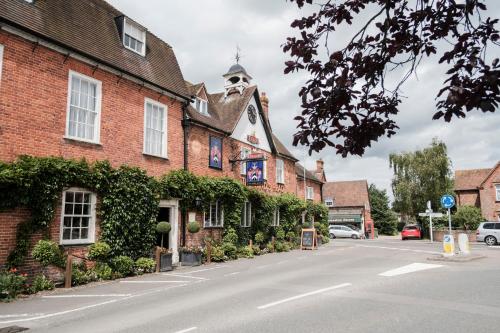 a building with ivy on the side of a street at Hinds Head in Aldermaston