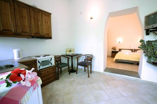 a kitchen with a table and a room with a bed at Anastasia Studios in Tinos Town