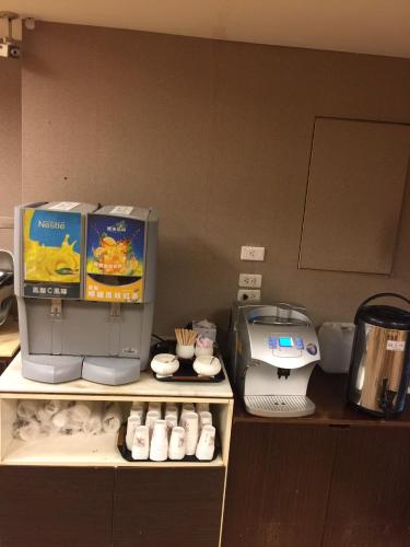 a kitchen with a coffee maker and a printer on a shelf at Unique Hotel in Hualien City
