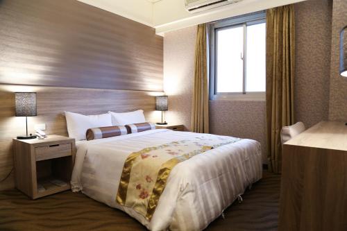 a hotel room with a large bed and a window at Unique Hotel in Hualien City