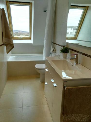 a bathroom with a toilet and a sink and a tub at San Ciprian Atico Playa by I Love Norte in San Ciprián