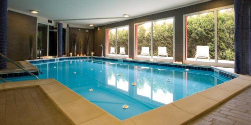 a large swimming pool in a building with windows at Hotel San Martino in Boario Terme