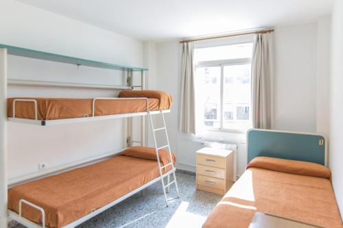 A bed or beds in a room at Albergue Inturjoven Granada