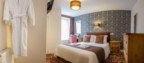 a hotel room with a bed and a robe on the wall at The Trafford Hotel in Blackpool