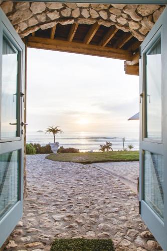 an open door to the beach with a view of the ocean at Villa Pescatori in Yzerfontein
