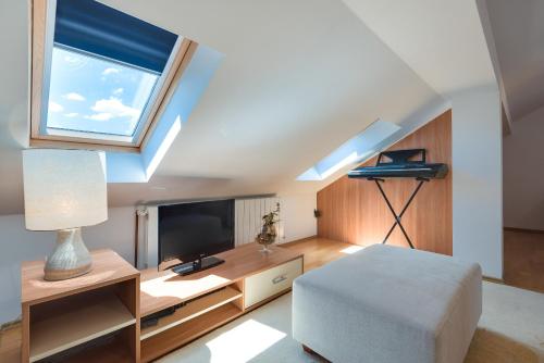 een woonkamer met een bed, een tv en een raam bij Studio Maslina in Šibenik