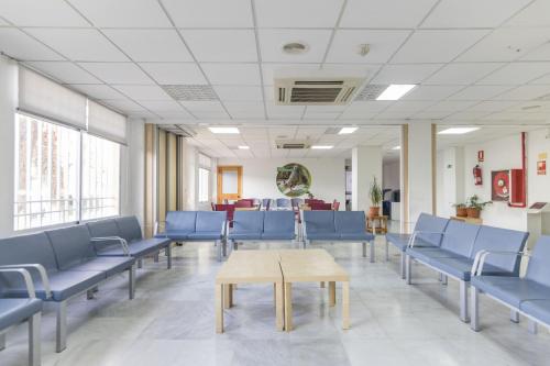 a waiting room with blue chairs and a table at Albergue Inturjoven Granada in Granada