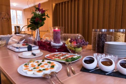 a table with plates of food and bowls of fruit at Seminarhaus in der Akademie in Waren