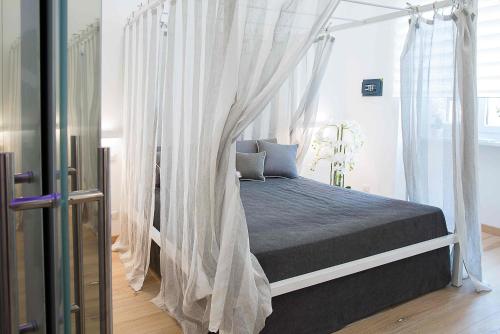 een slaapkamer met een hemelbed en witte gordijnen bij Relais Dolcevita in Rome