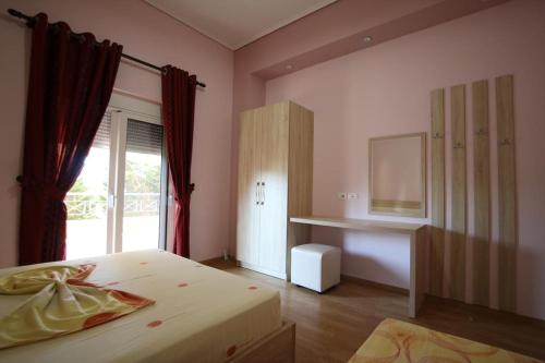 a bedroom with a bed and a desk and a window at Apartment Eclipse in Sarandë