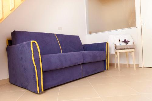 a blue couch in a living room with a table at Via dei Mari Guest House in Oristano