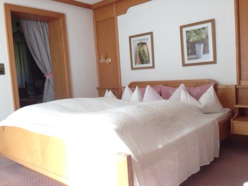 a large white bed in a hotel room at Haus Guentli in Mittelberg