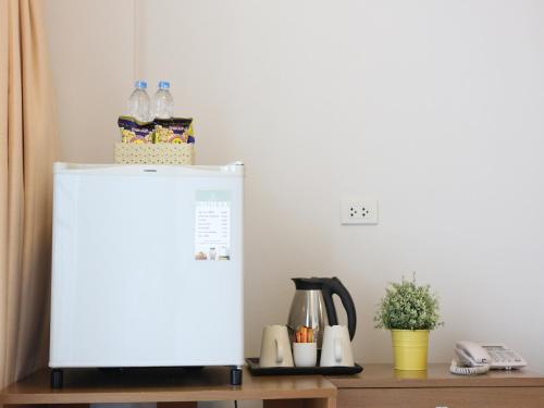 a white refrigerator in a kitchen with a table at The Ivory, Suvarnabhumi Airport in Lat Krabang