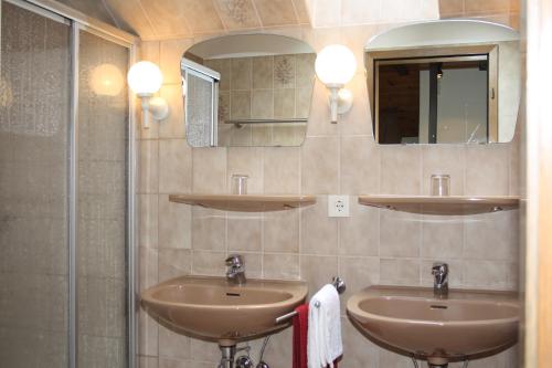 łazienka z 2 umywalkami i lustrem w obiekcie Haus Schwalbennest w mieście Undeloh