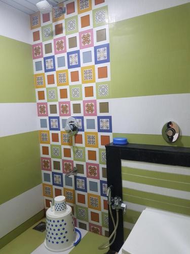 a room with a wall covered in different colored tiles at Hotel Laabh in Diu