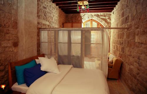 a bedroom with a bed in a brick wall at Tyre Boutique Apartments in Soûr