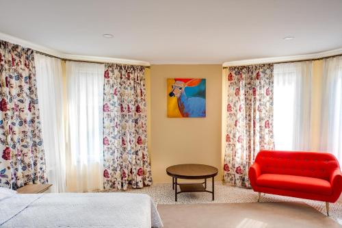 a bedroom with a red couch and a red chair at LETIZIA country club in Shaian