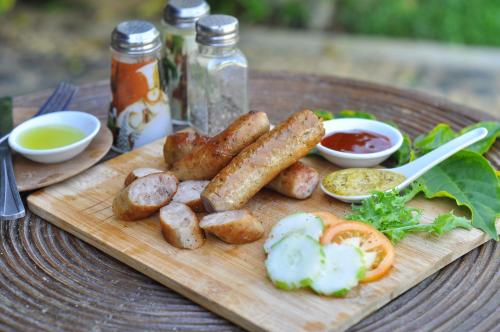 a wooden cutting board with sausages and potatoes on a table at Lio Villas Resort in El Nido