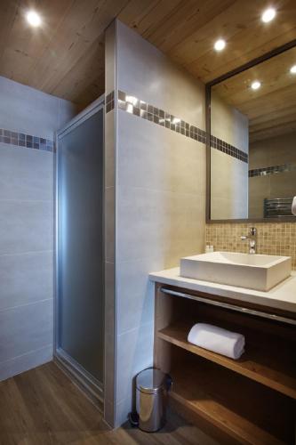 une salle de bain avec un lavabo et un miroir dans l'établissement Chalet des Neiges -La Source des Arcs, à Arc 2000