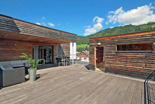 una gran terraza de madera con una casa en Appartements Waluliso by Schladming-Appartements en Schladming