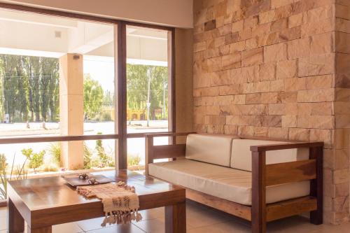a living room with a bench and a table at Hotel Malargue in Malargüe