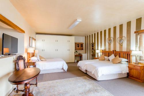 a large bedroom with two beds and a table at Villa Pescatori in Yzerfontein