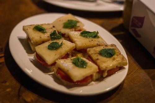 a plate of tofu sandwiches with green leaves on it at Hotel Raniban Arcade in Pokhara