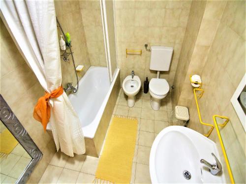uma casa de banho com um WC, uma banheira e um lavatório. em Apartment Arco Climbing em Arco
