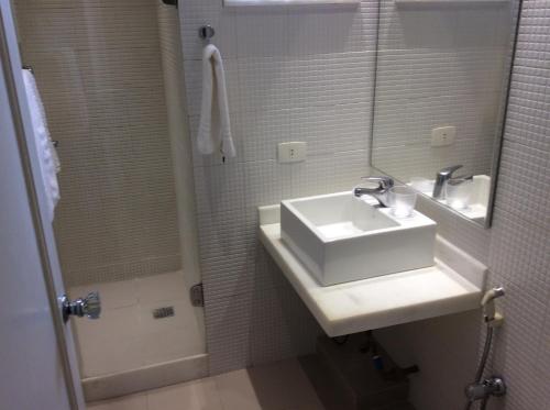 uma casa de banho com um lavatório, um espelho e um chuveiro em Ipa Penthouse Prudente no Rio de Janeiro