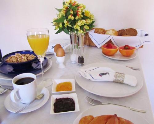 a table with breakfast foods and a glass of orange juice at Bed & Breakfast Kortenhoefsedijk in Kortenhoef