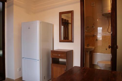 a kitchen with a white refrigerator and a sink at Гостевой дом "Kalinka" in Cholpon-Ata