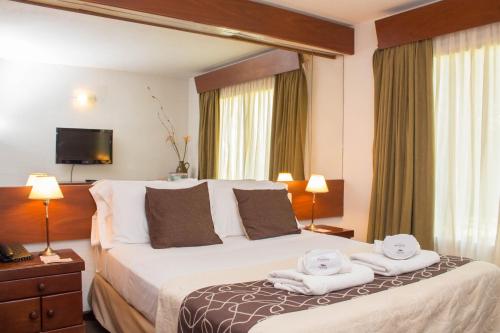 Una habitación de hotel con una cama con toallas. en Hotel Malargue en Malargüe