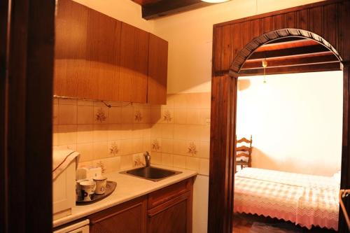 eine kleine Küche mit einem Waschbecken und einem Bett in der Unterkunft Eleonora in Chania