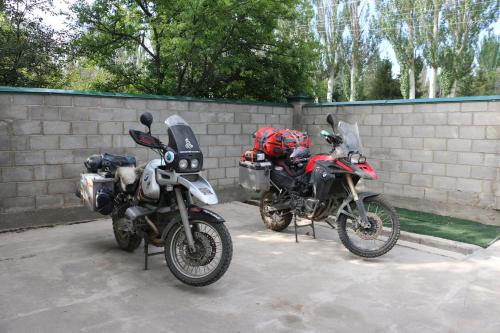 two motorcycles parked next to a brick wall at Hostel Nice in Karakol