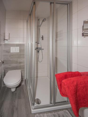 a bathroom with a shower with a toilet and a red towel at Ferienwohnung Gaigg in Weyregg