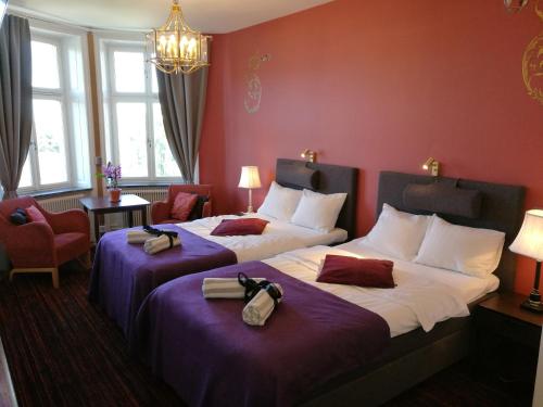 two beds in a hotel room with purple walls at Stockholm Classic Hotell in Stockholm