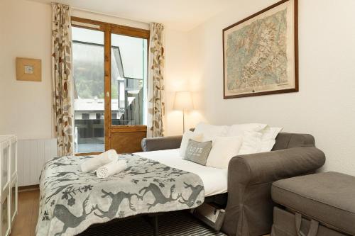een slaapkamer met een bed, een stoel en een raam bij Apartment Balme 2 in Chamonix-Mont-Blanc