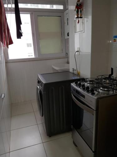 cocina pequeña con fogones y ventana en Apartamento Barra Paraíso Tropical en Río de Janeiro