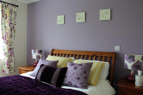 a bedroom with a bed with purple and yellow pillows at Luachra Lodge in Killarney