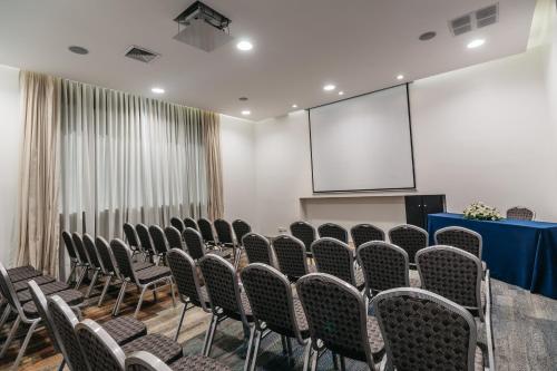 a conference room with chairs and a projection screen at Hotel Antofagasta in Antofagasta