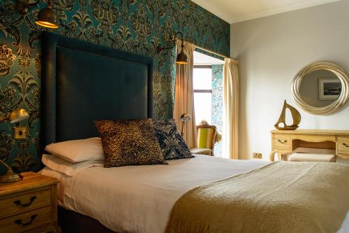 a bedroom with a large bed and a mirror at Bay View Hotel in Kilkee