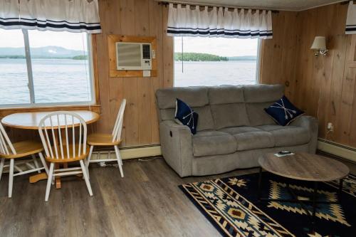 a living room with a couch and a table at Belknap Point Inn in Gilford