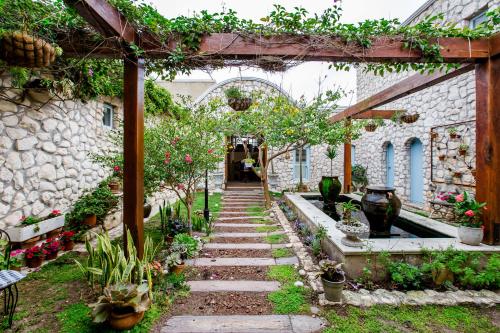 a garden with a stone archway with plants and flowers at Villa Pescatori in Yzerfontein