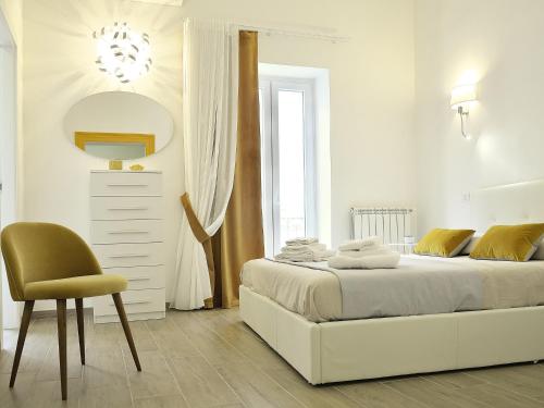 ターラントにあるDuca70 "Suite Home"の白いベッドルーム(ベッド1台、椅子付)