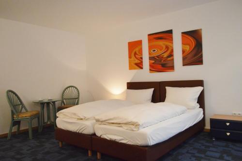 Hotel B8 Voerde في Voerde: سرير في غرفة بها لوحات على الحائط