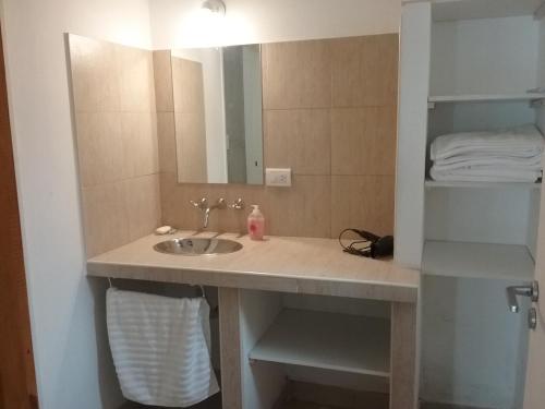 ein Badezimmer mit Waschbecken und Spiegel in der Unterkunft El Alamo in Sierra de la Ventana